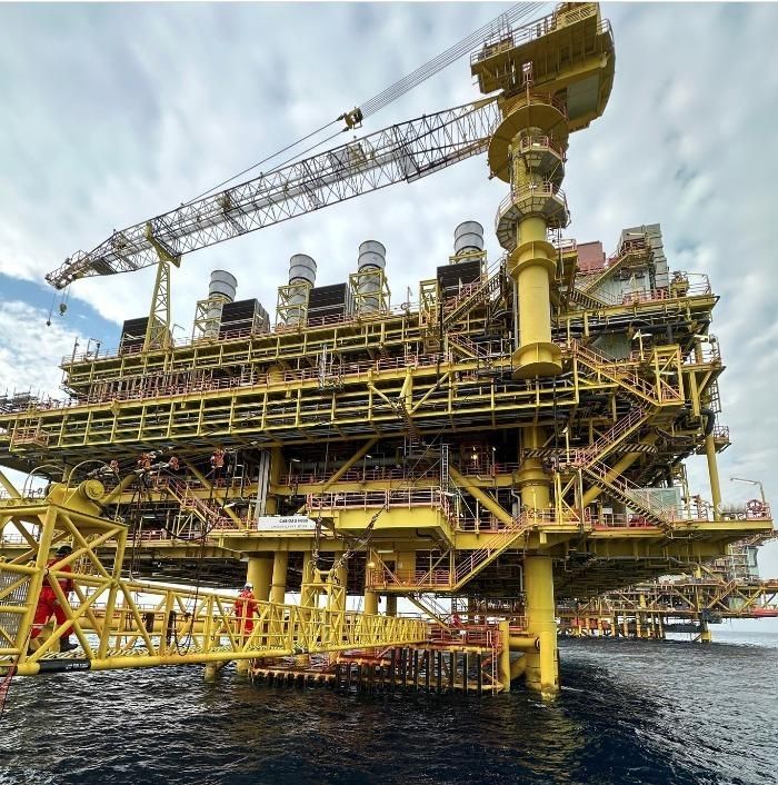Yellow offshore production platform with lattice-boom crane